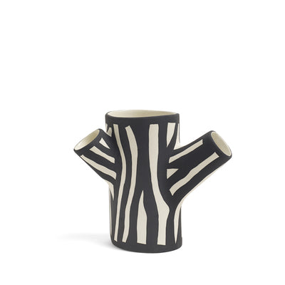 Tree Trunk is a collection of iconic decorative vases made in a stoneware ceramic. Glazed on the inside and hand-painted on the outside, the large three-armed or small two-armed versions feature the artist’s signature wood grain pattern on the tree trunk-shaped vase.
